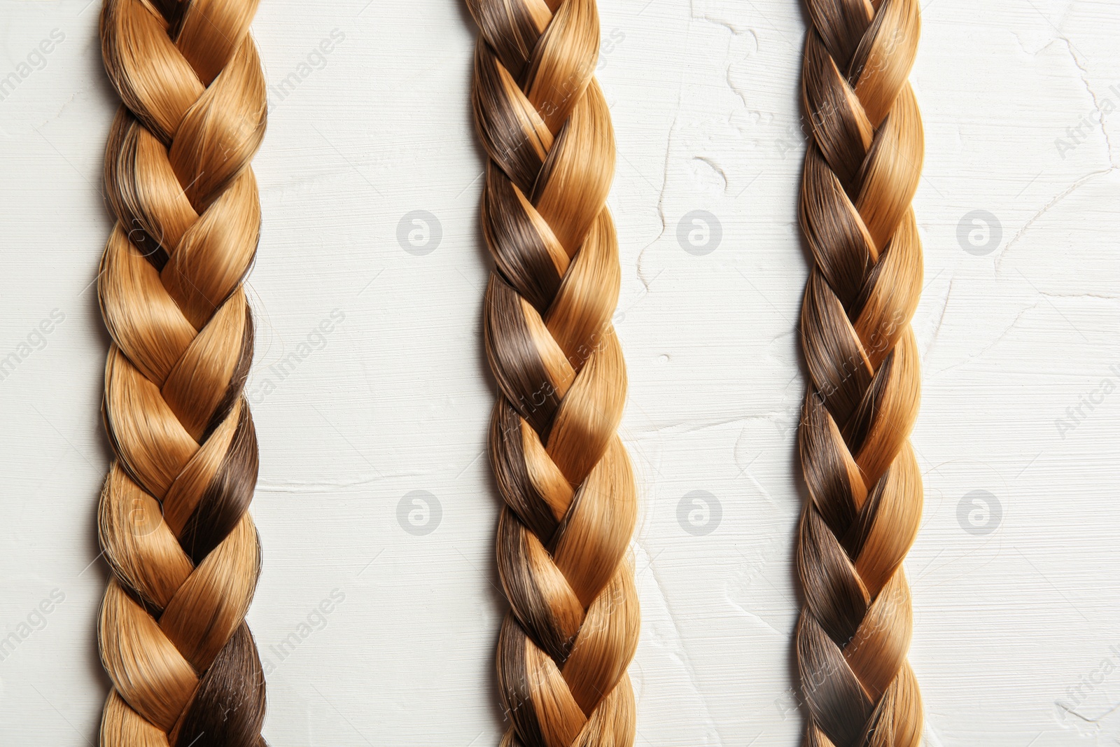 Photo of Flat lay composition with braids on light background. Healthy hair