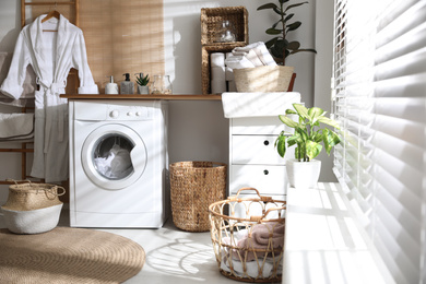 Photo of Stylish bathroom interior with modern washing machine