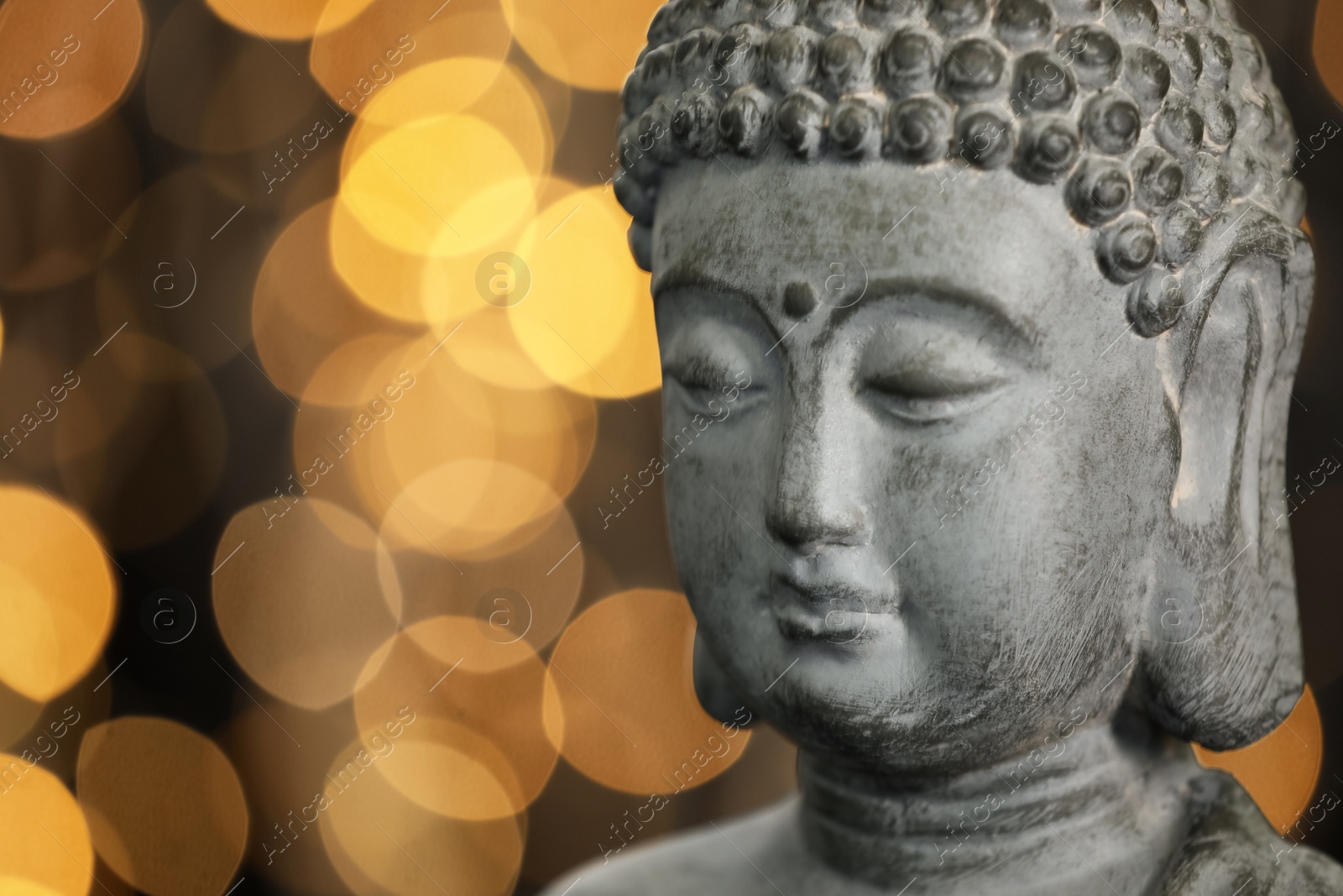 Photo of Buddha statue against blurred lights, closeup. Space for text