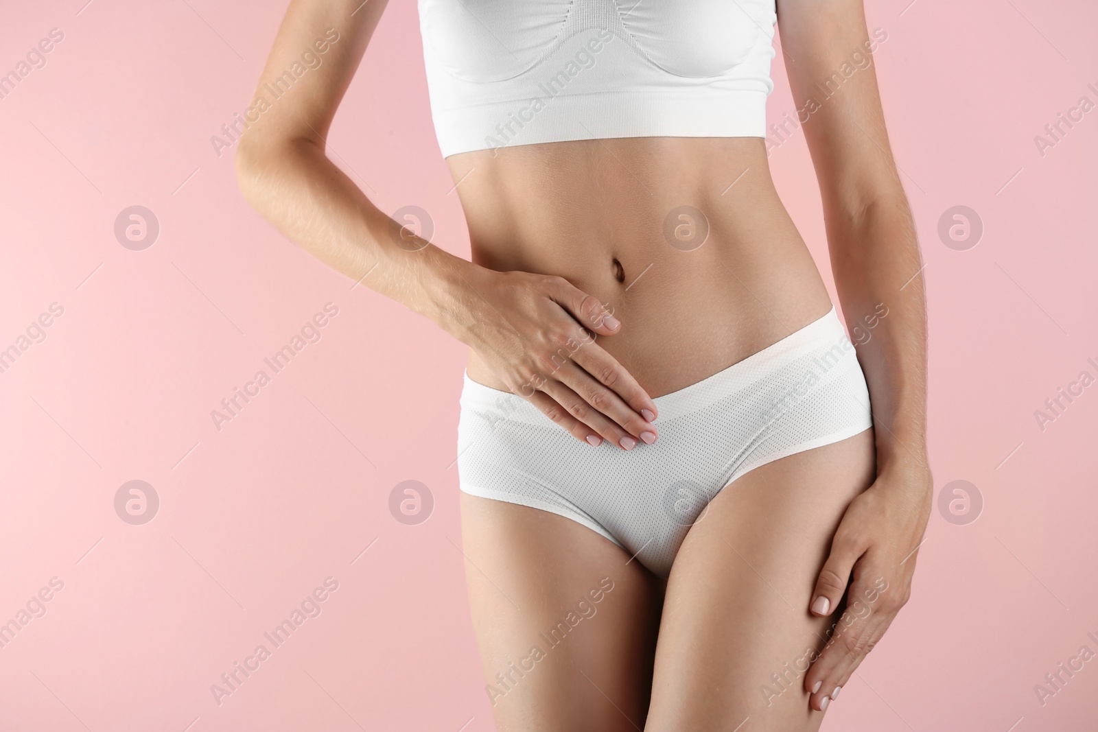 Photo of Young woman holding hands near panties on color background. Gynecology concept