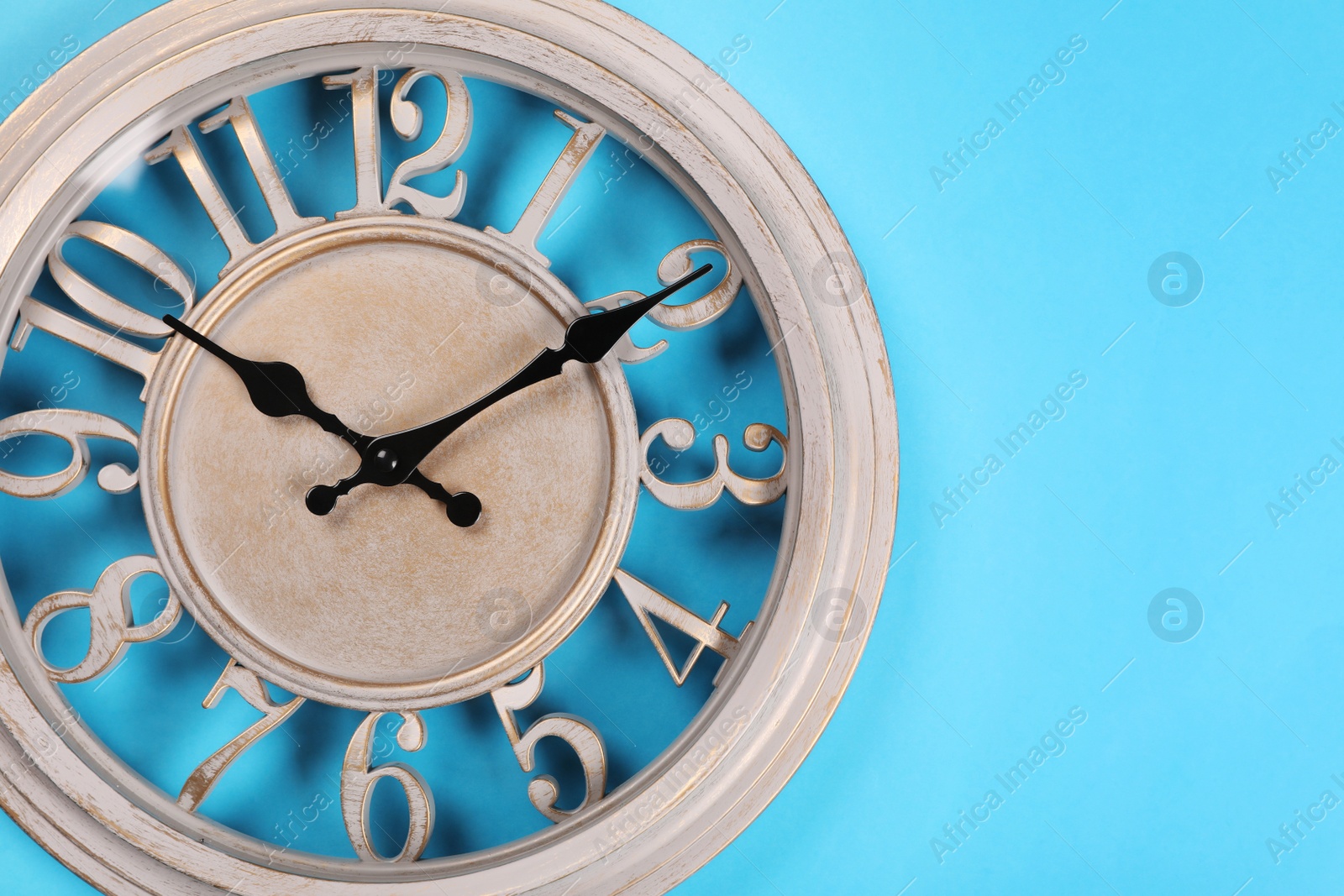 Photo of Stylish wall clock on turquoise background, top view with space for text