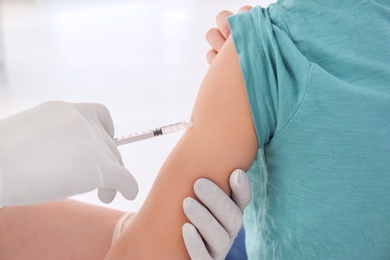 Doctor vaccinating little boy in hospital