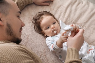 Father spending time together with his daughter on blanket, top view