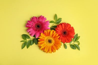 Photo of Flat lay composition with beautiful bright gerbera flowers on color background