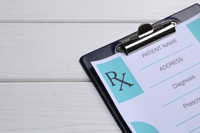 Photo of Clipboard with medical prescription form on white wooden table. Space for text