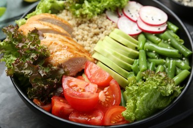 Photo of Healthy meal. Tasty products in bowl on black wooden table, closeup