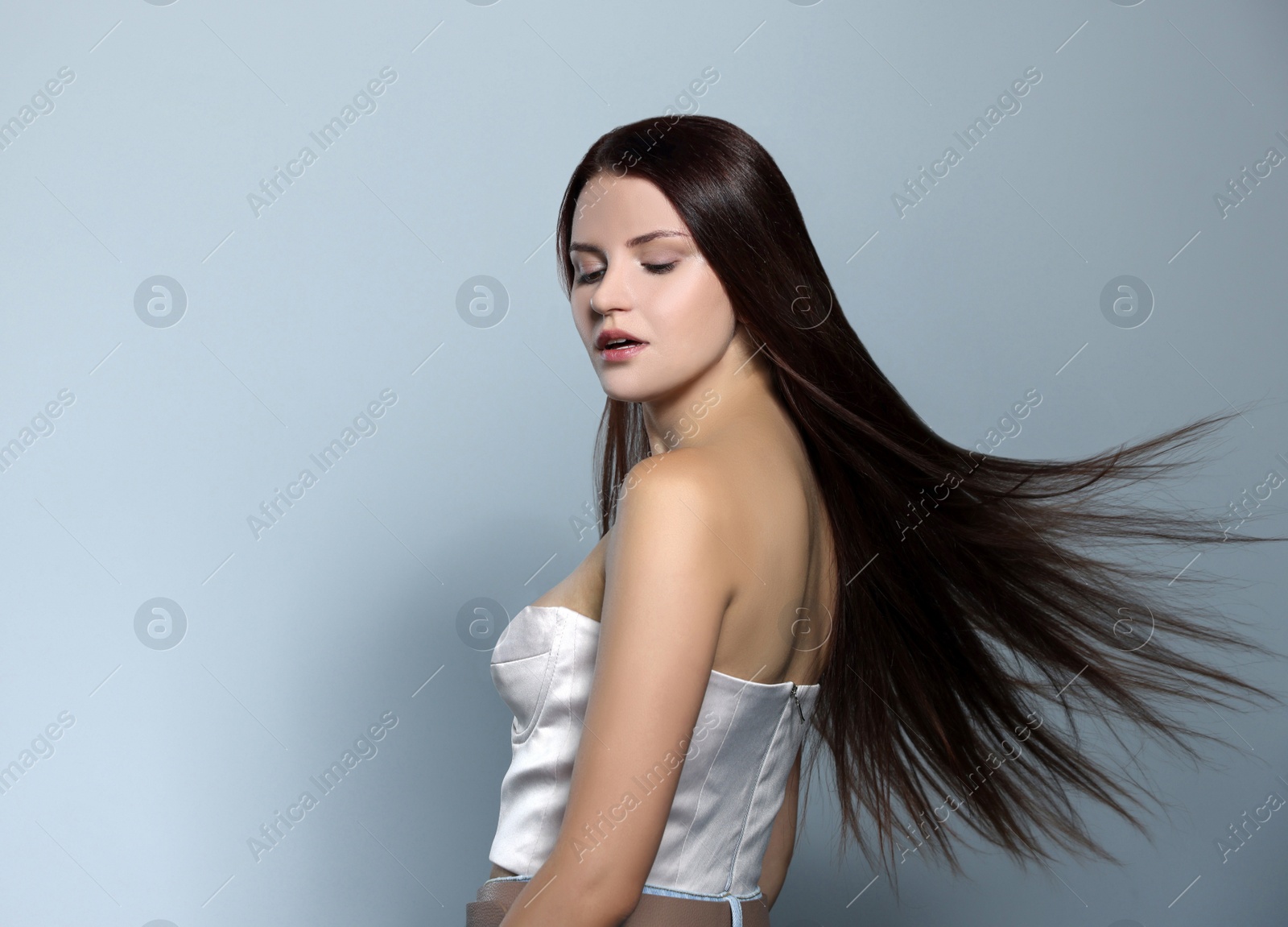 Photo of Portrait of beautiful young woman with healthy strong hair on light gray background, space for text