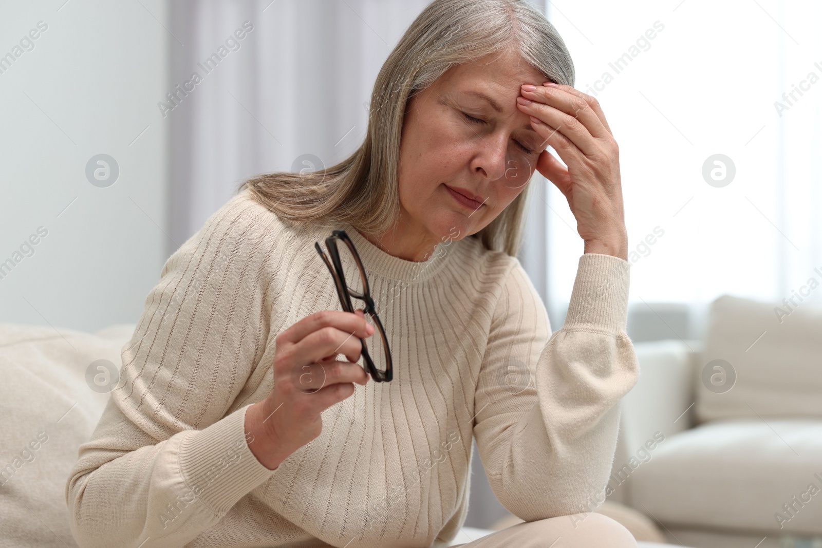 Photo of Overwhelmed woman with glasses suffering at home