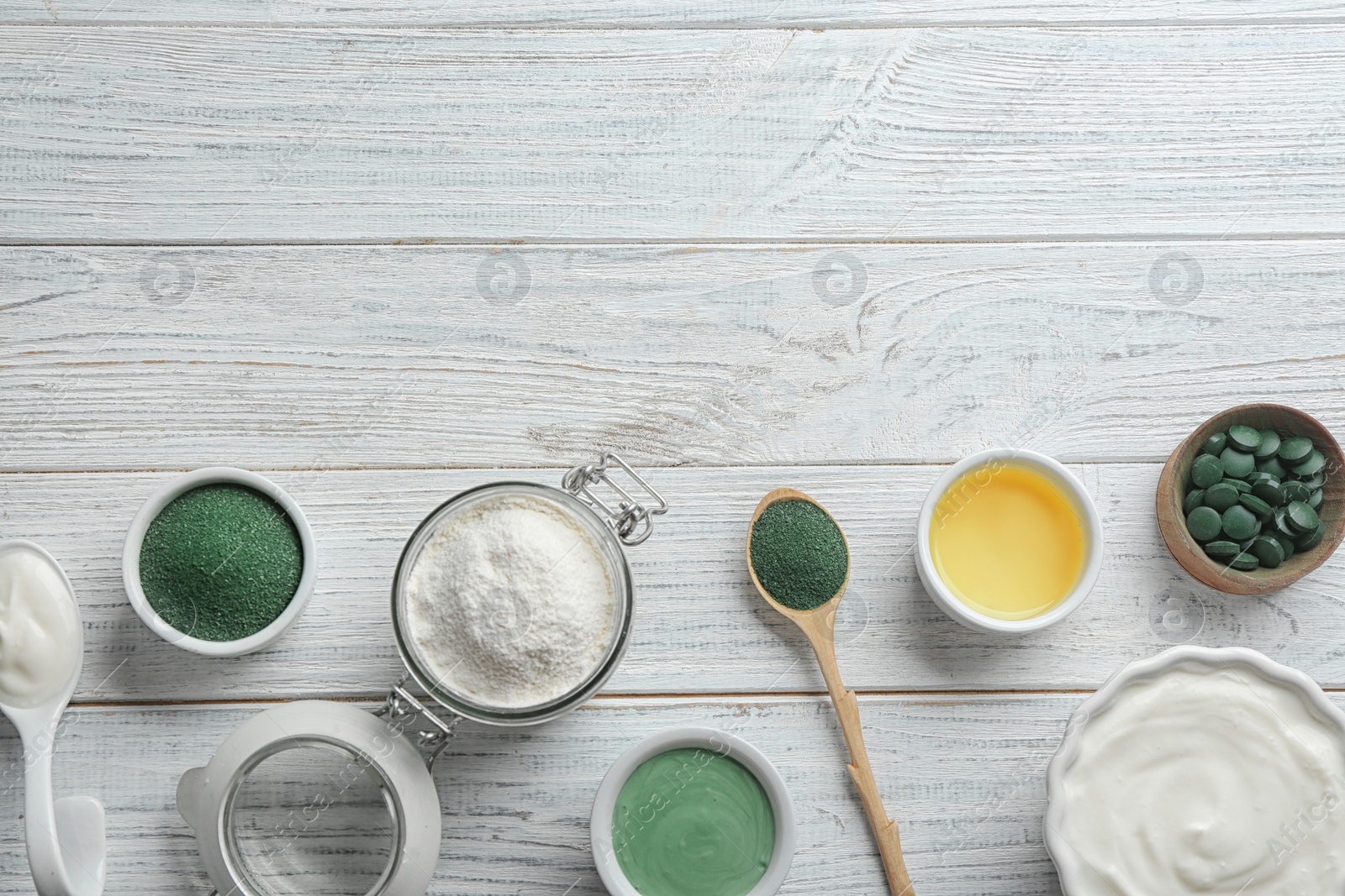 Photo of Flat lay composition with freshly made spirulina facial mask on white wooden table. Space for text