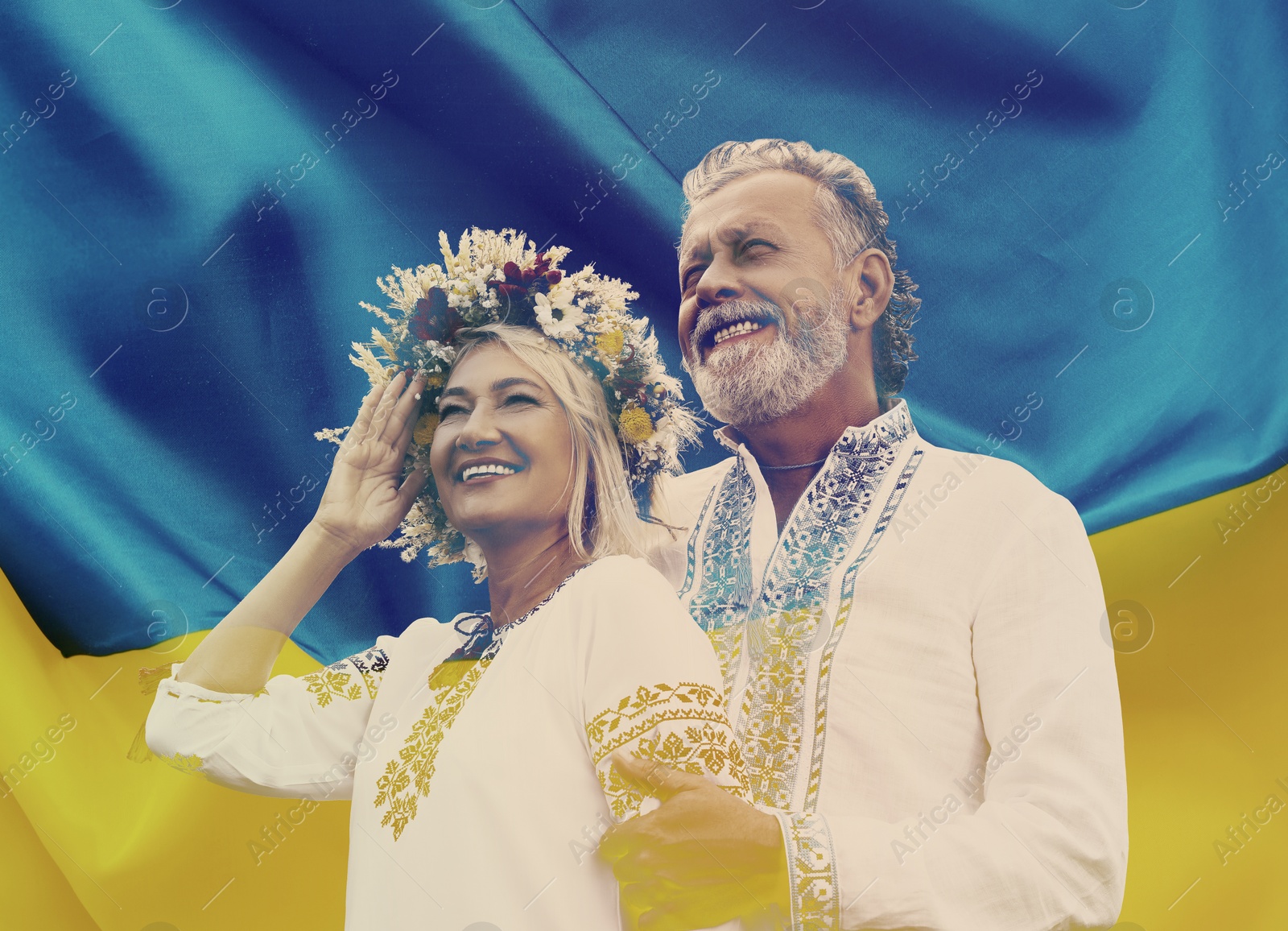 Image of Double exposure of happy mature couple wearing national clothes and Ukrainian flag