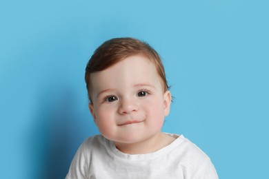 Photo of Cute little baby boy on light blue background