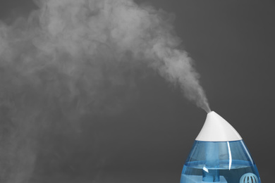 Photo of Modern air humidifier on grey background, closeup. Space for text