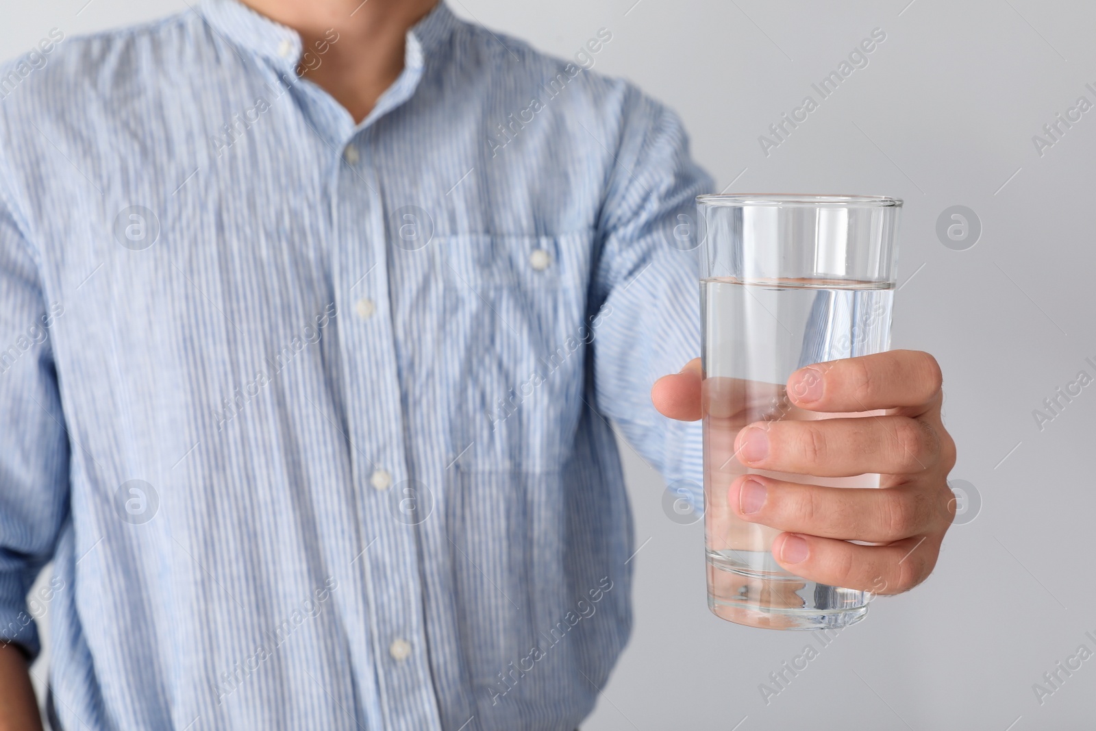 Photo of Man holding glass of pure water on white background, closeup