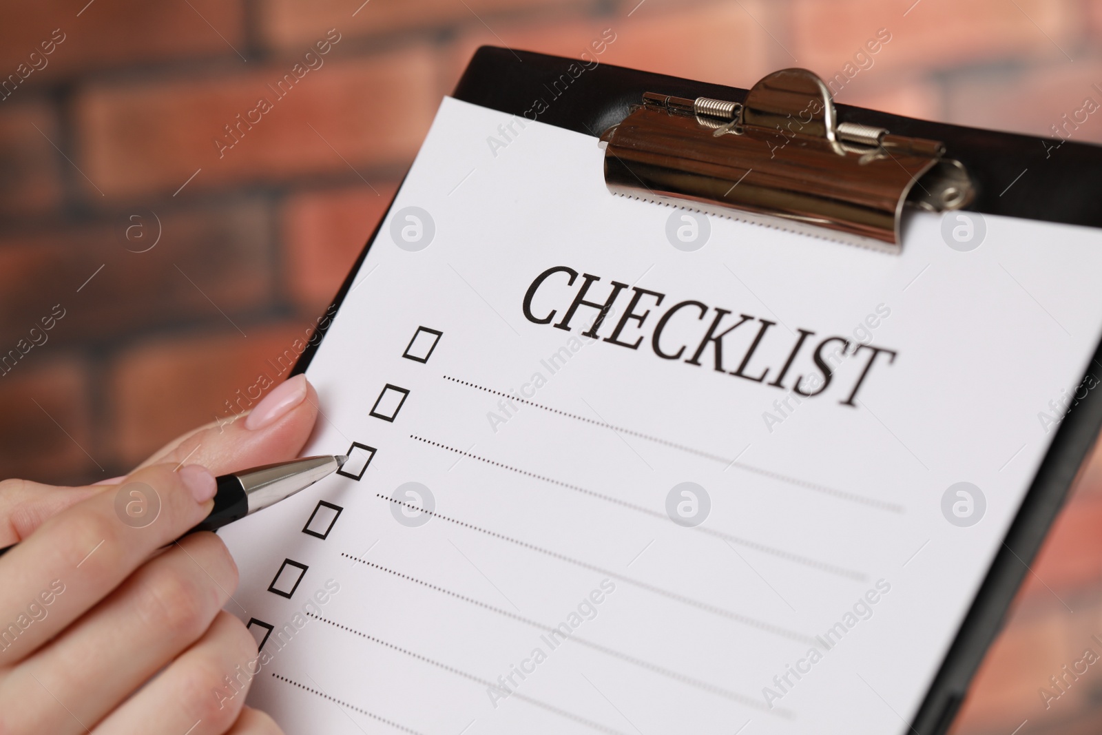 Photo of Woman filling Checklist with pen, closeup view