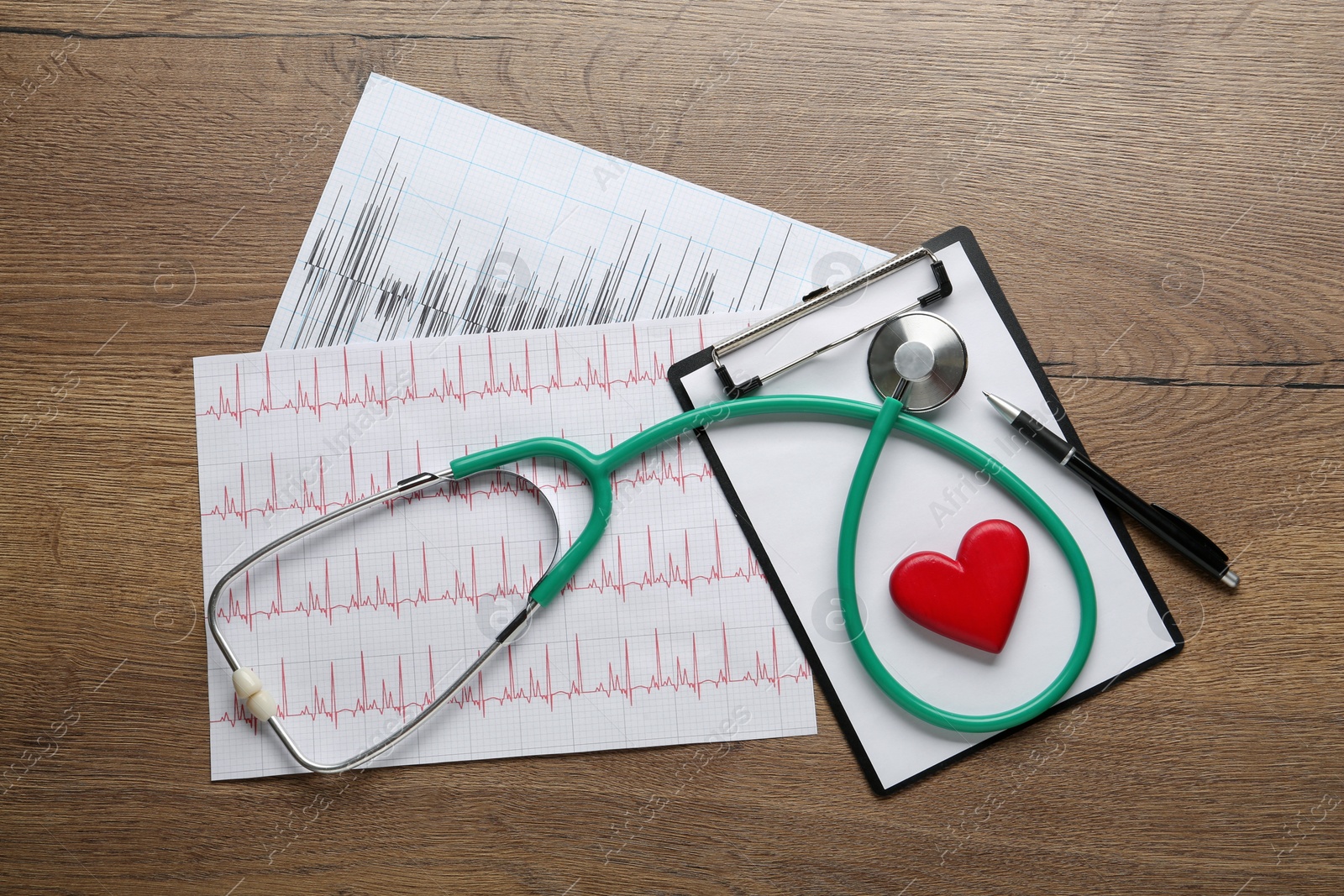 Photo of Flat lay composition with stethoscope and red heart on wooden table. Cardiology concept