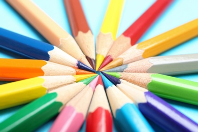 Photo of Composition with colorful pencils on light blue background, closeup