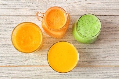 Glassware with delicious detox smoothies on wooden background