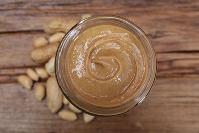 Tasty peanut nut paste in jar on table, top view