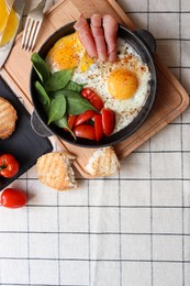Photo of Delicious fried eggs with spinach, tomatoes and ham served on table, flat lay. Space for text