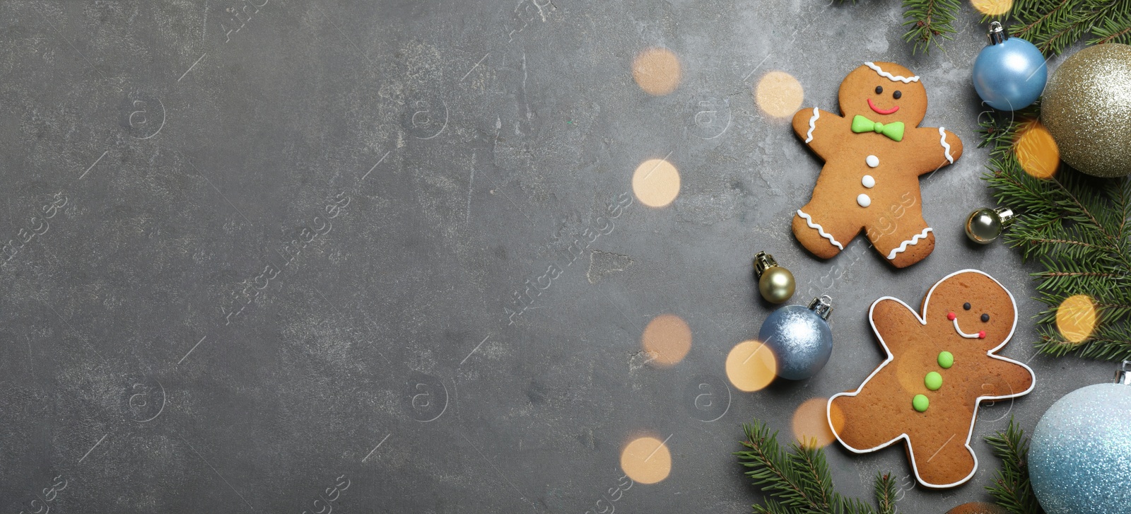 Image of Flat lay composition with gingerbread men on grey table, space for text. Banner design