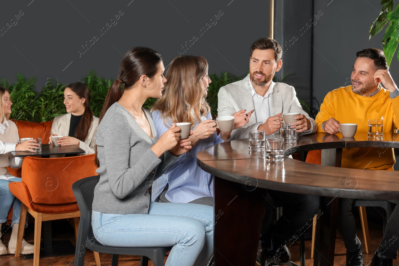 Photo of Friends with drinks spending time together in cafe