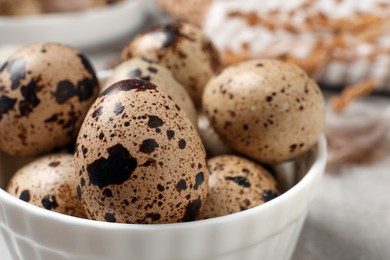 Photo of Fresh quail eggs in bowl on table, closeup