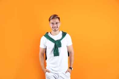 Photo of Young man with trendy hairstyle on color background