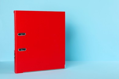 Photo of Red office folder on light blue background, space for text