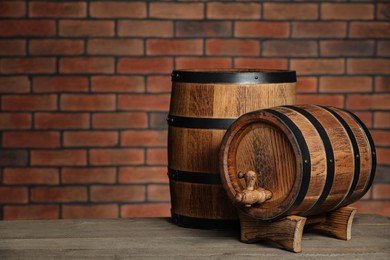 Wooden barrels on table near brick wall, space for text