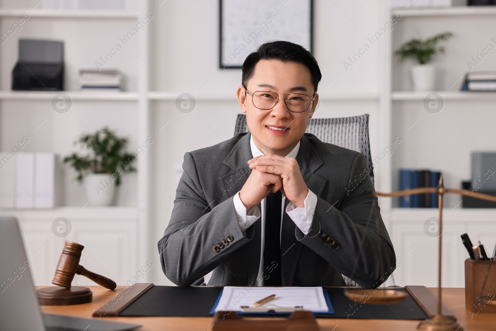 Photo of Happy notary working at wooden table in office