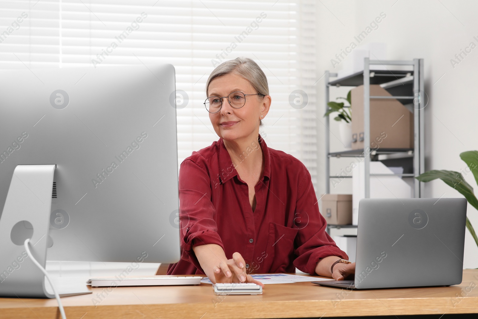 Photo of Senior accountant working at wooden desk in office