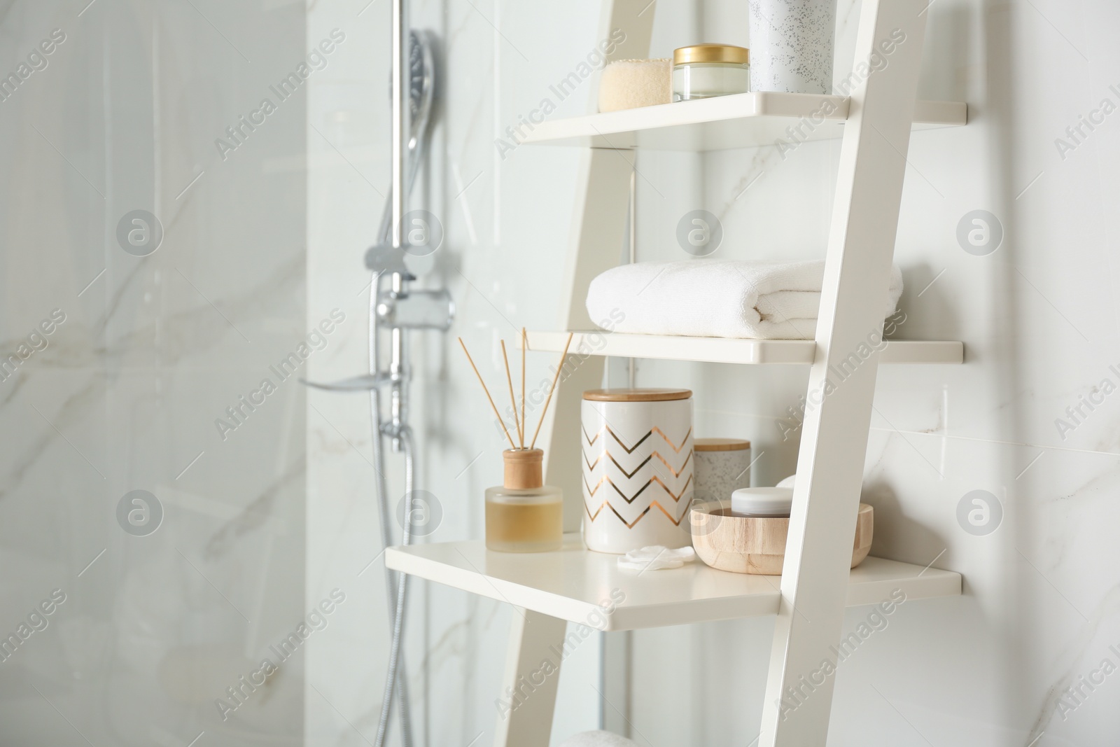 Photo of Shelving unit with different items in bathroom interior