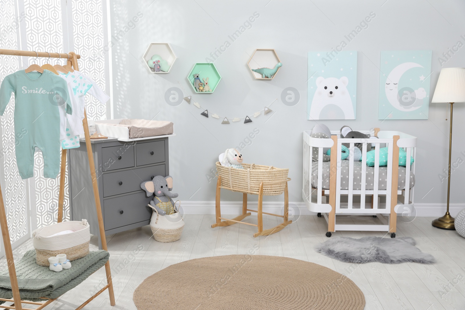 Photo of Cozy baby room with crib and other furniture. Interior design