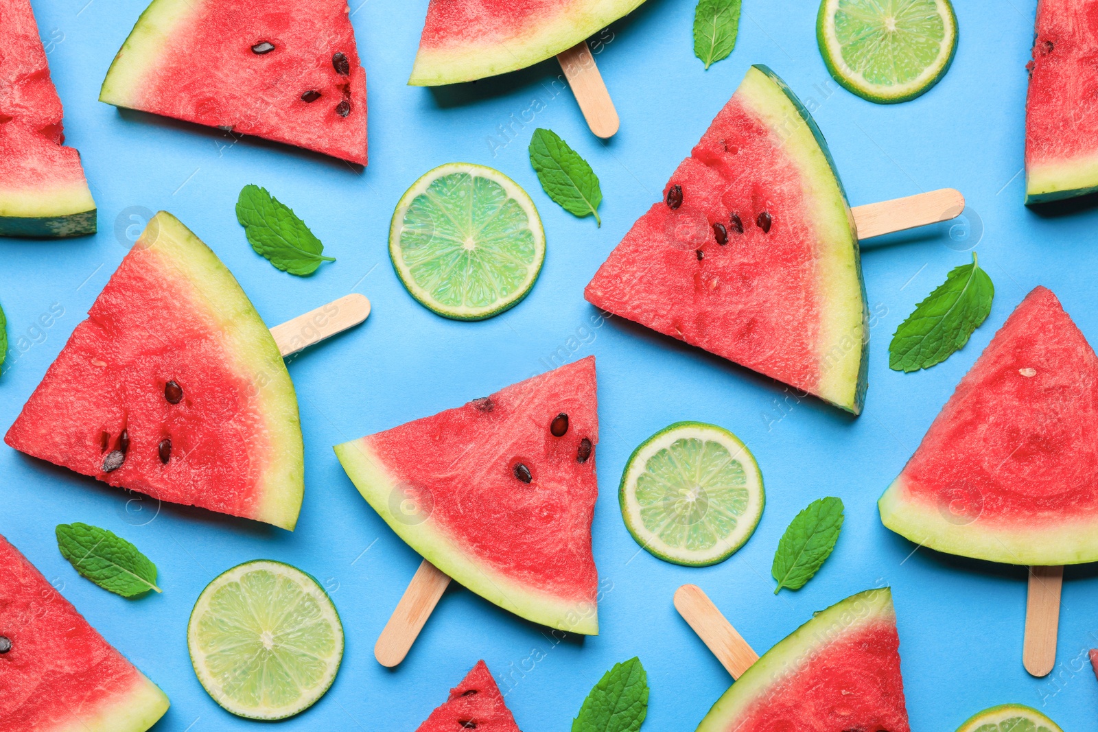 Photo of Tasty sliced watermelon and limes on light blue background, flat lay