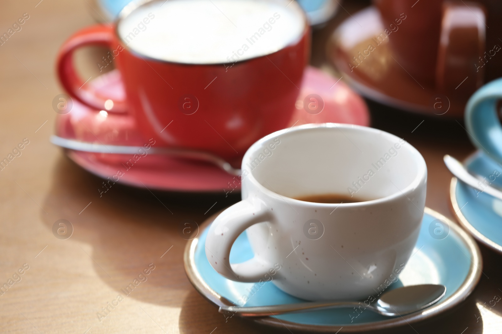 Photo of Cups of fresh aromatic coffee on wooden table