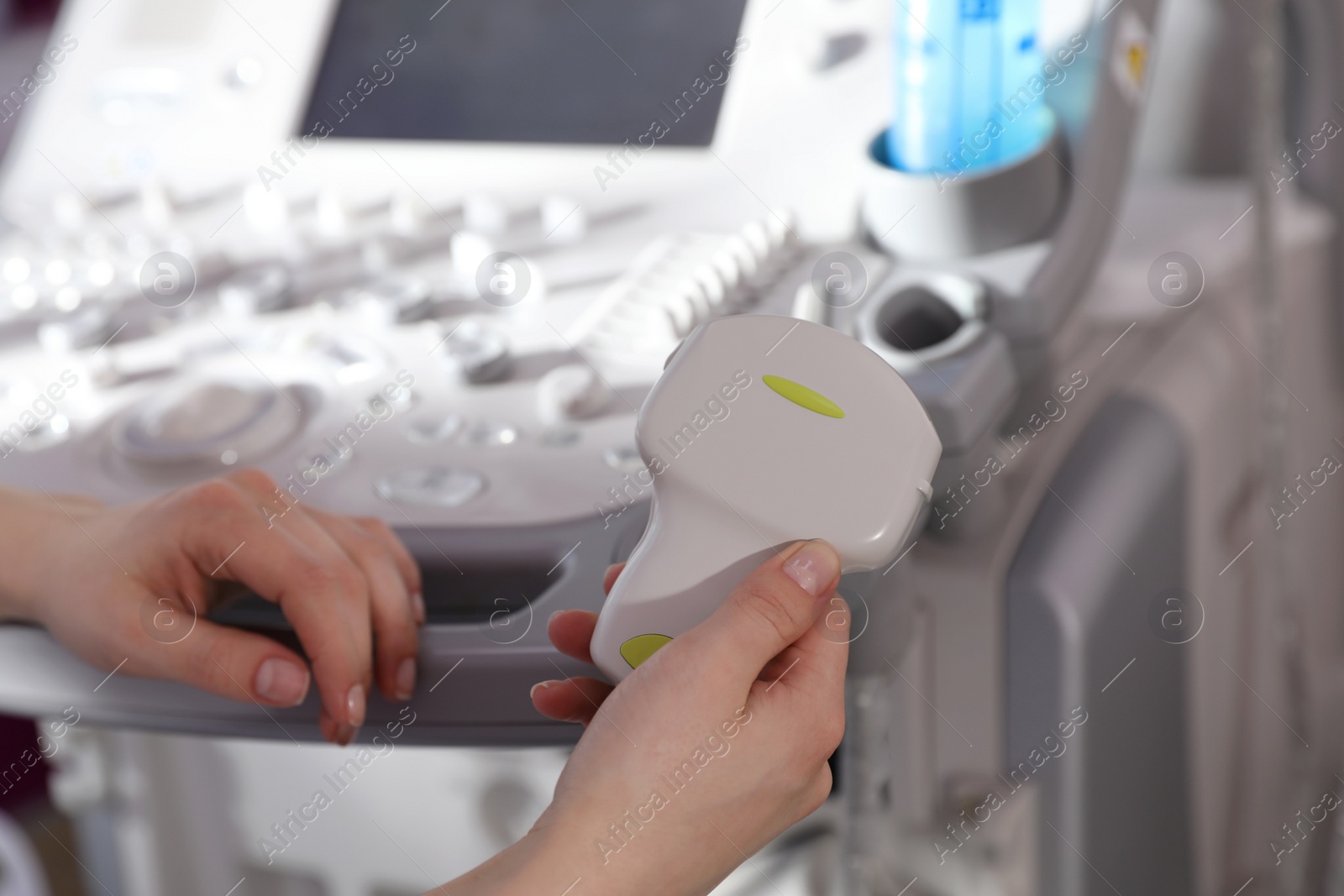 Photo of Sonographer holding ultrasound machine probe in clinic, closeup