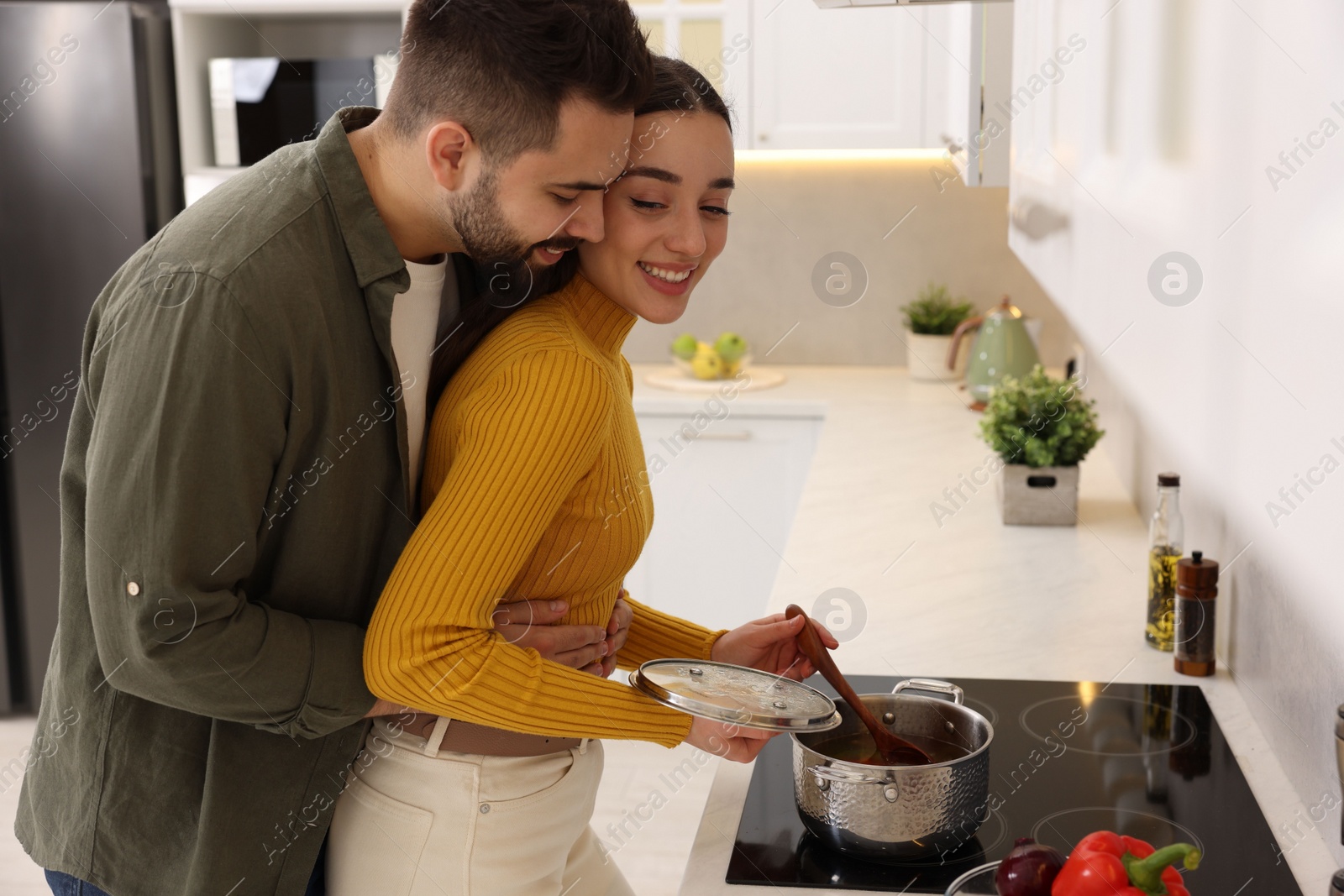 Photo of Lovely couple enjoying time together while cooking in kitchen