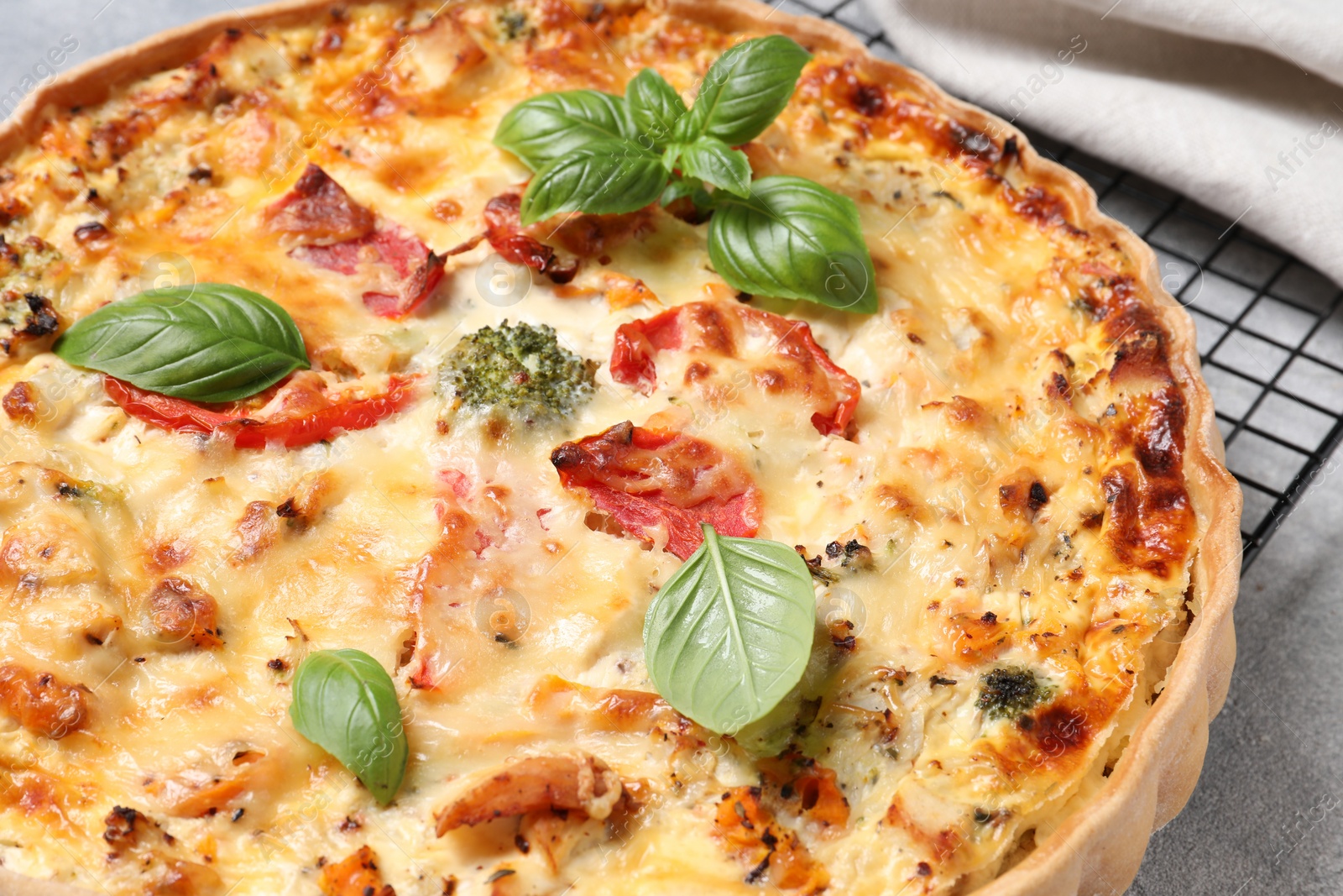 Tasty quiche with tomatoes, basil and cheese on light textured table, closeup Photo of Tasty quiche with tomatoes, basil and cheese on light textured table, closeup