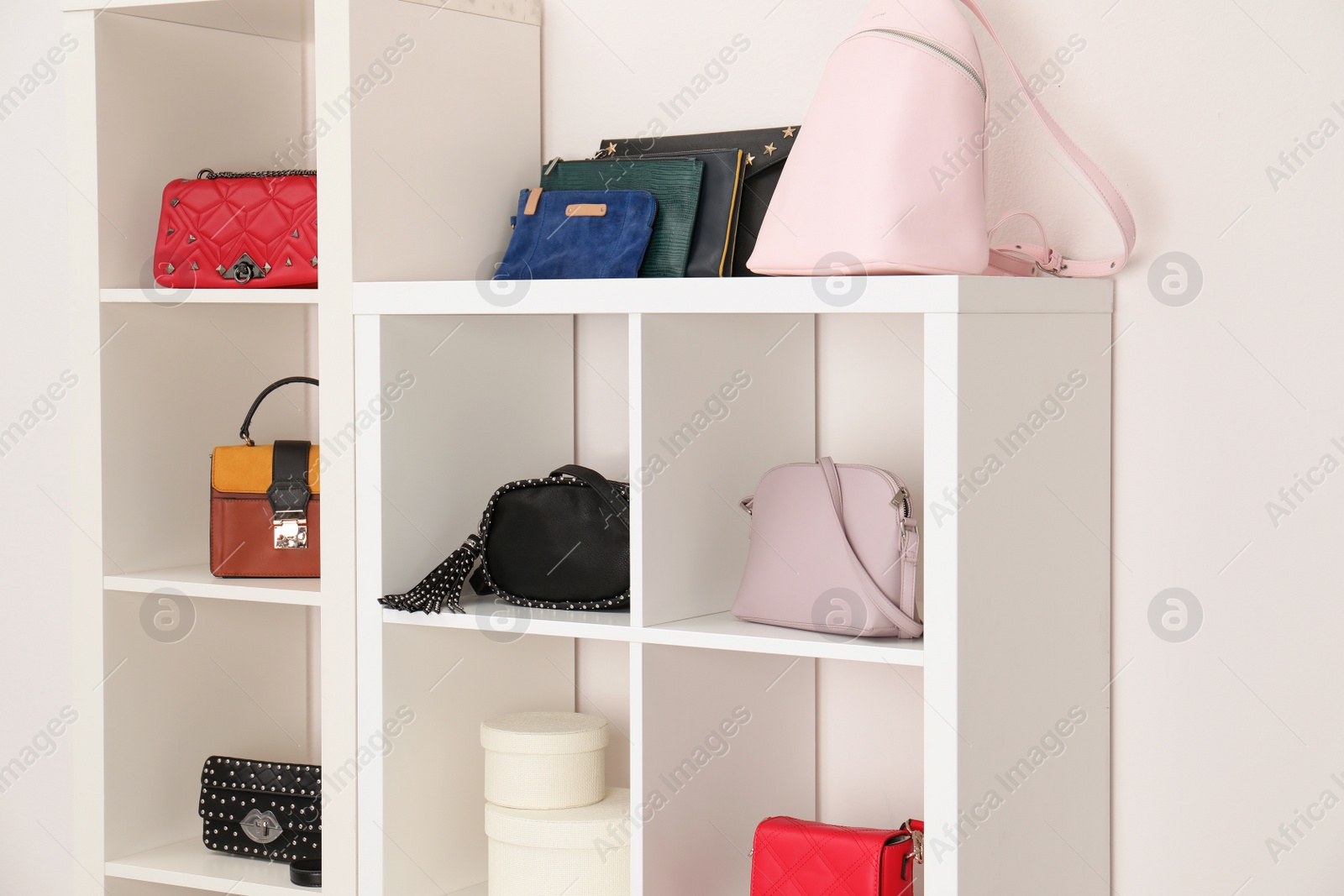 Photo of Wardrobe shelves with different stylish bags indoors. Idea for interior design