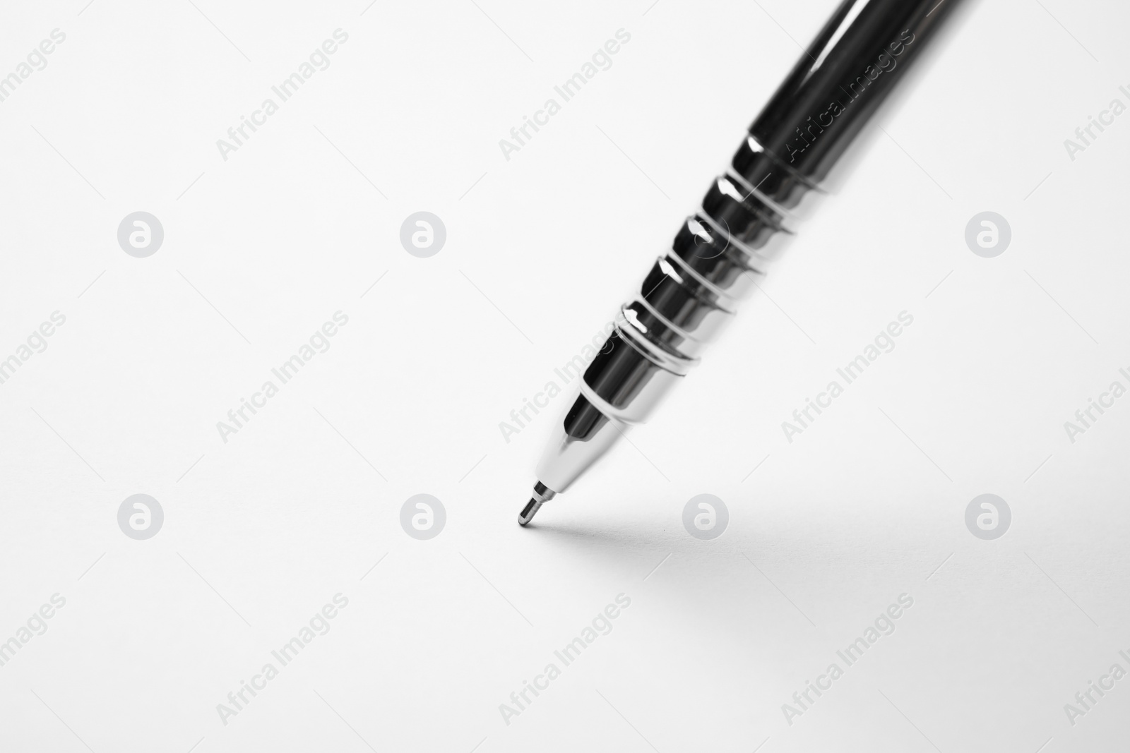 Photo of Writing on sheet of white paper with pen, closeup