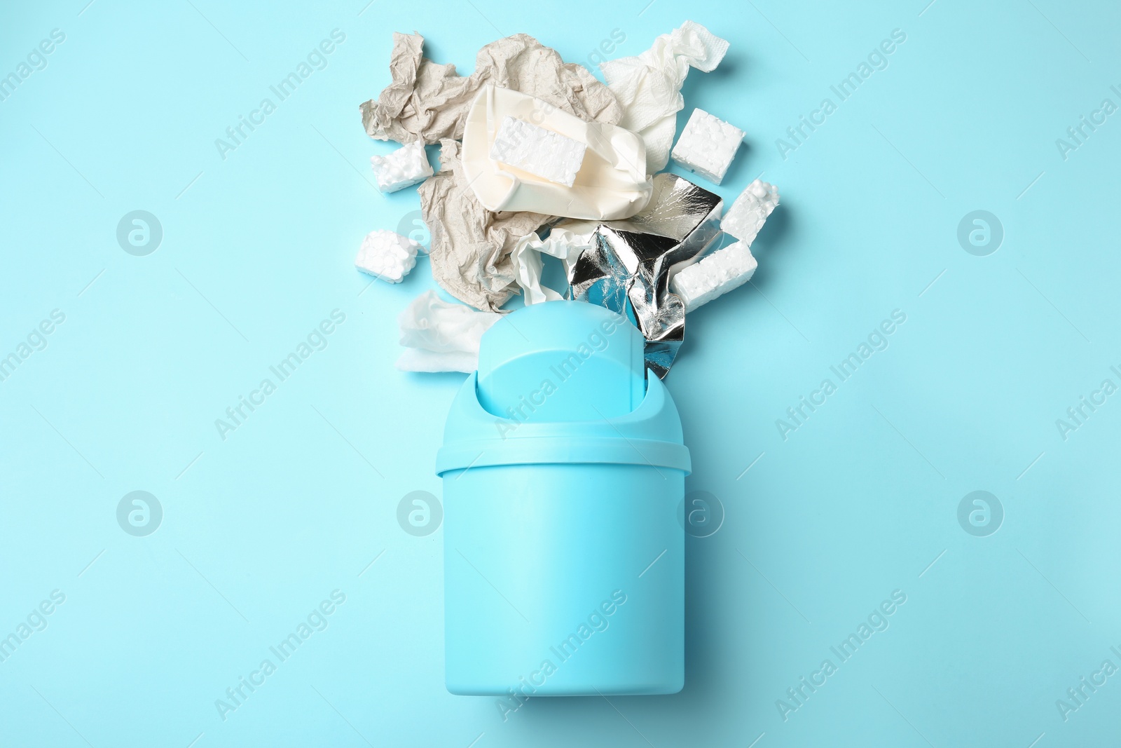 Photo of Trash bin and different garbage on color background, top view. Waste recycling concept