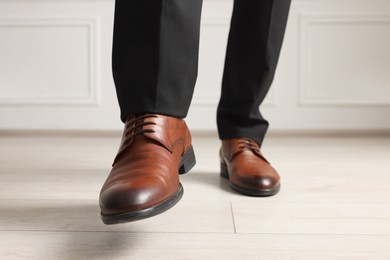 Photo of Businessman in elegant leather shoes indoors, closeup