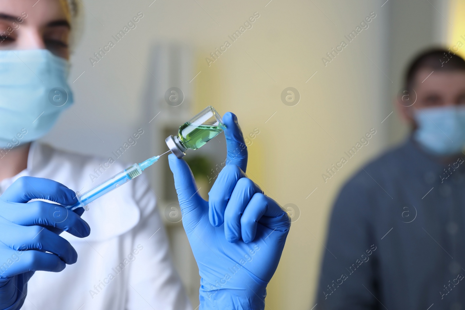 Photo of Doctor filling syringe with medication in clinic, focus on hands. Vaccination and immunization