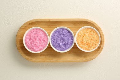 Photo of Bowls with colorful sea salt on white table, top view