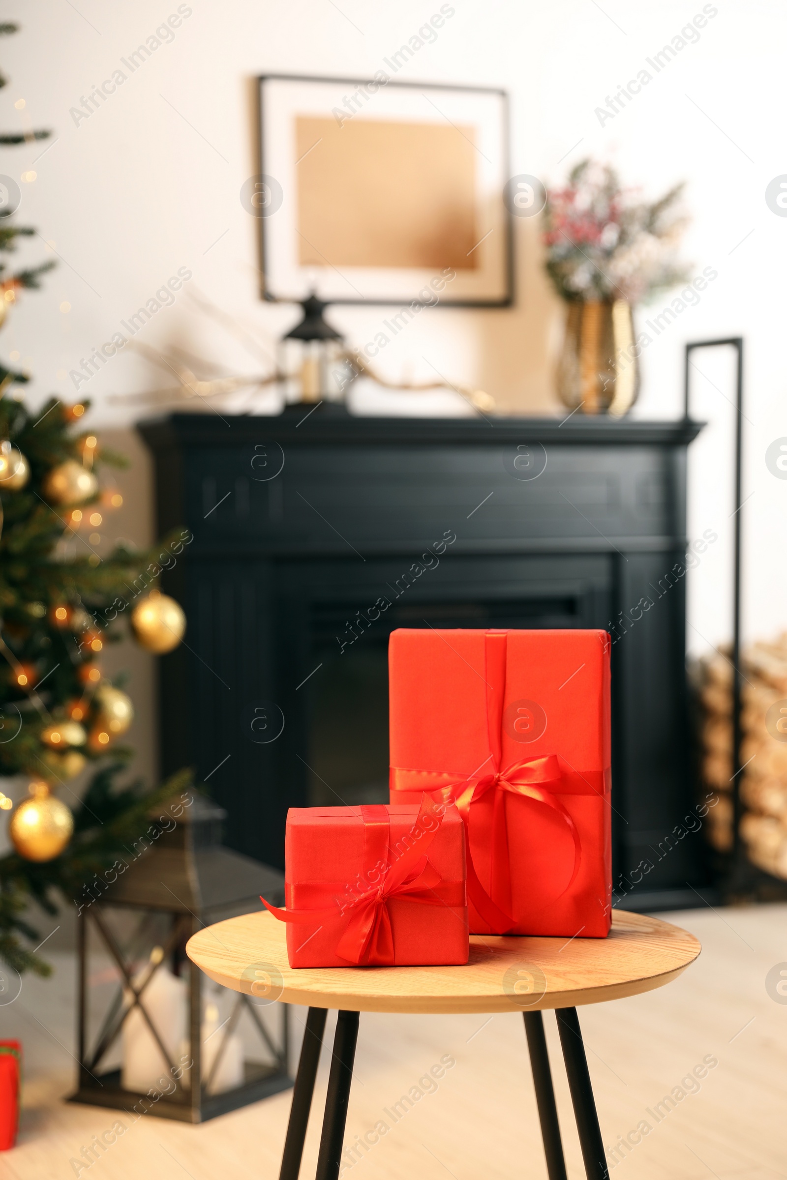 Photo of Beautifully wrapped Christmas gifts on wooden table in living room