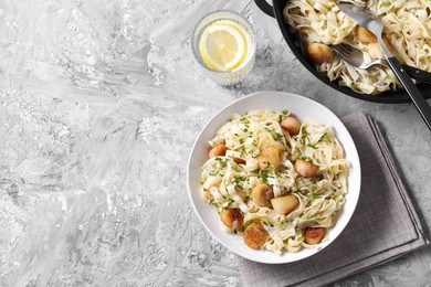 Photo of Delicious scallop pasta with spices served on gray textured table, flat lay. Space for text