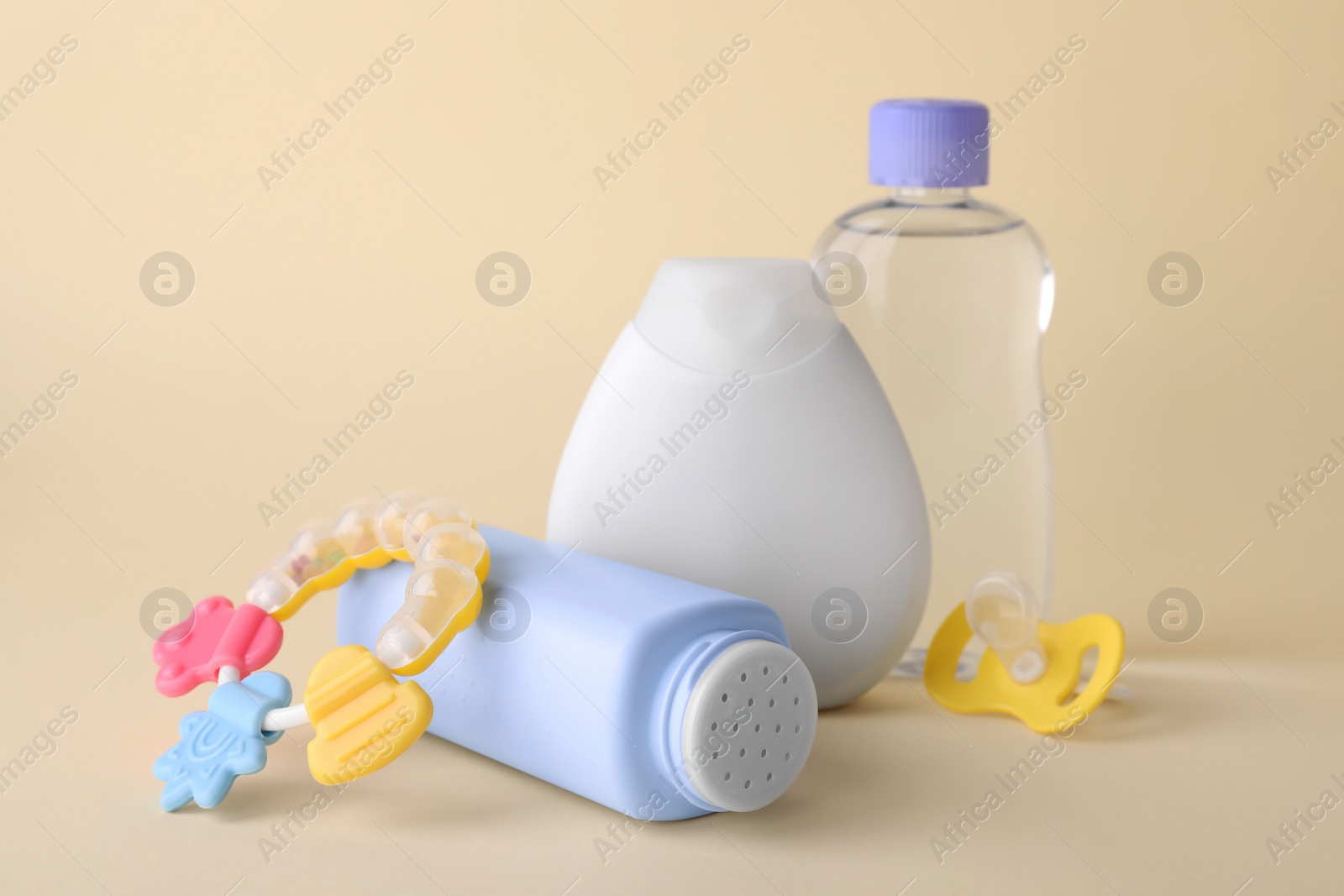 Photo of Different skin care products for baby, rattle and pacifier on beige background. Space for text