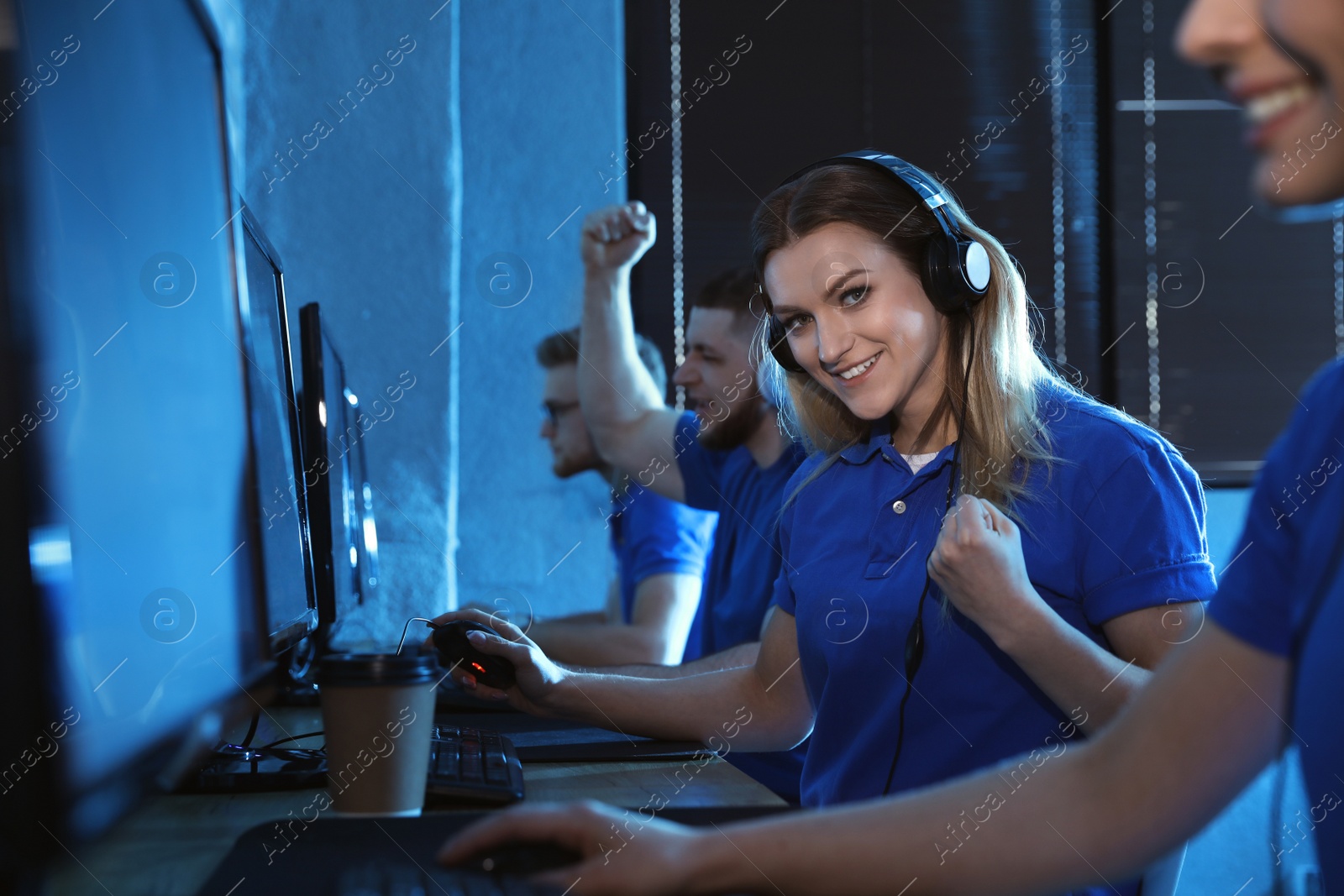 Photo of Group of people playing video games in internet cafe