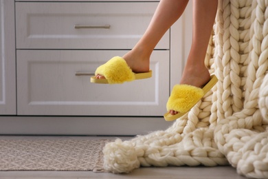 Photo of Woman in fuzzy slippers at home, closeup. Weekend morning