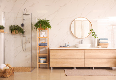 Photo of Stylish bathroom interior with countertop, shower stall and houseplants. Design idea